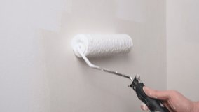 Roller painting wall with white paint. Painting out a bare wall with a paint roller with white paint. 4K resolution video