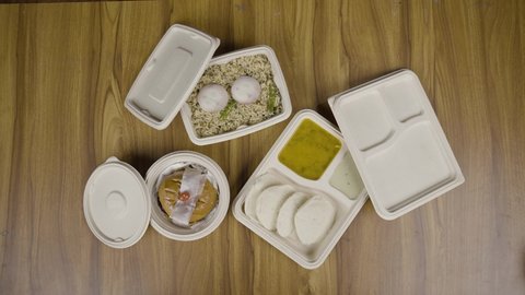 zoom in shot of south indian food items packed on biodegradable food packs or boxes on table - concept of Eco-friendly, reuseable and sustainable lifestyle