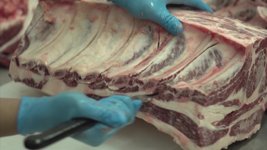 Close-up video Meat industry, butcher cut raw meat with a knife at table in the slaughterhouse, Wagyu Beef. Royalty-Free Stock Footage #1086274520