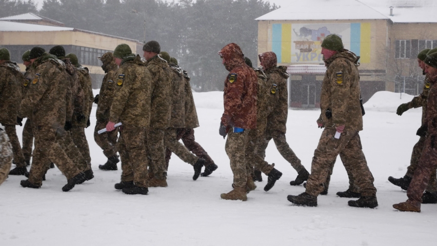 Kharkiv, Ukraine - January, 31, 2022: Ukrainian soldiers with backpacks and weapons march in formation. Ukrainian army prepares for Russian invasion