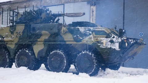 Kharkiv, Ukraine - January, 31, 2022: An armored personnel carrier of the Ukrainian army is driving through the snow. Preparations for the Russian invasion of Ukraine