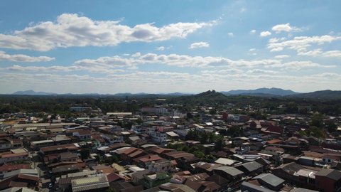Aerial footage over the Walking Street in Chiang Khan revealing rooftops and the mountains in the horizon, Loei, Thailand.