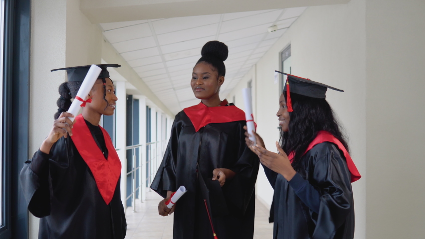 Group of joyful afro american students jumping with diplomas. Prosess of university studies. Master of Science
