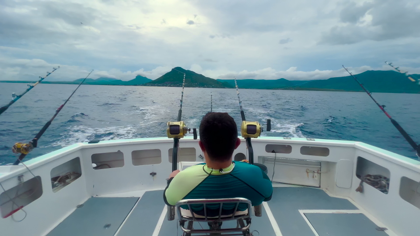 A fisherman on a motorboat catches a big fish of marlin and tuna. Big game fishing reels and rods reels and rods