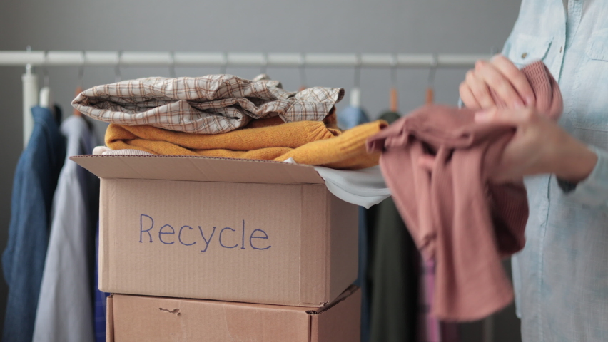 a woman collects clothes in a box for recycling or disposal.european woman sorting plastic and garbage eco friendly lifestyle and caring for the planet. disassemble the wardrobe at home for donation Royalty-Free Stock Footage #1086306710