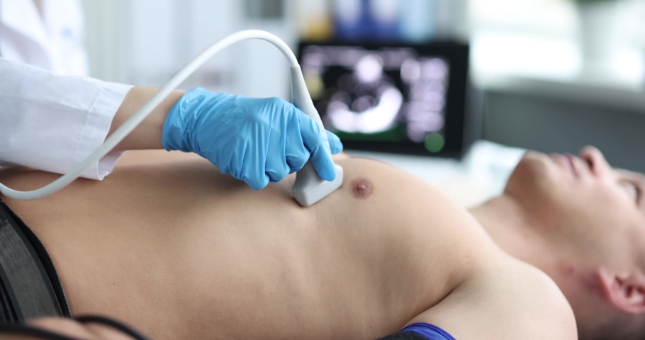 Doctor doing heart ultrasound to young man in clinic 4k movie | Shutterstock HD Video #1086307895