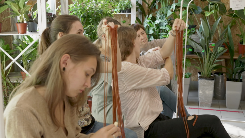 Group of women attending art class. Female students and teacher makes home decor in Boho style in workshop together. Weaves handmade macrame at art school studio. Creativity, people education | Shutterstock HD Video #1086308936