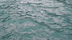 Sea waves. Sun reflection on water surface. Disturbed water surface. Teal color of the sea.