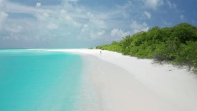 Girl walking on a white sand beach on a tropical island in the Maldives