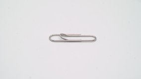 Paper clip. Metal steel clip for documents and paperwork in office, rotates on white isolated background. Business and contract.