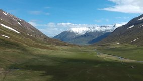 Scenic Icelandic Valley, shot by drone, with views of snow capped mountains