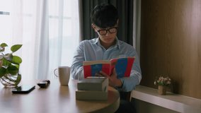 Young attractive asian vietnamese man is busy working learning on desk book at home data analyst, data science scientist for business.