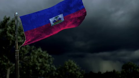 waving Haiti flag for memorial day on dark storm cumulus clouds
