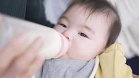 Asian baby drinking milk while sleeping