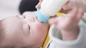 Asian baby drinking milk while sleeping