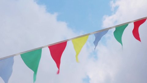 multi-colored flags on rope against blue sky with clouds Video HD