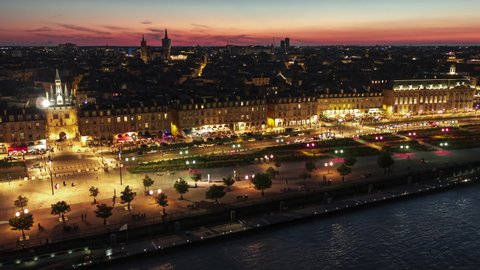 Sun Setting over city, Establishing Aerial View Shot of Bordeaux Fr, world capital of wine, Nouvelle-Aquitaine, France at night evening