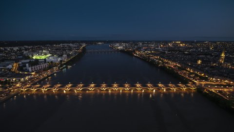 Track in, Iconic Stone Bridge, Establishing Aerial View Shot of Bordeaux Fr, world capital of wine, Nouvelle-Aquitaine, France at night evening