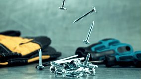 Screws fall on the table. On a gray background. Filmed is slow motion 1000 frames per second. High quality FullHD footage - Powered by Shutterstock - Get 15% off with code: PIKWIZARD15