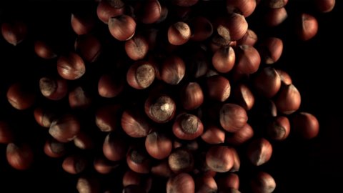 Super slow motion hazelnuts rise up and fall. On a black background. Filmed on a high-speed camera at 1000 fps.High quality FullHD footage