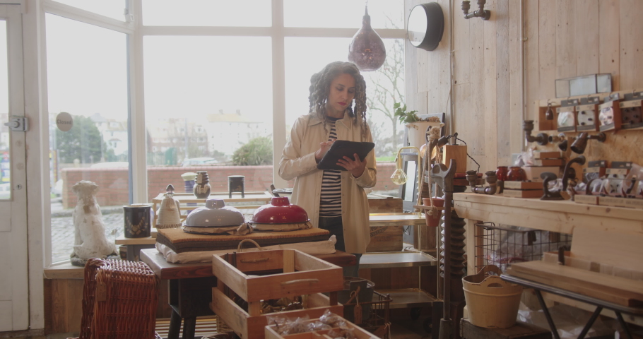 Mature Female Small Business Owner Working on Digital Tablet in Interior Store