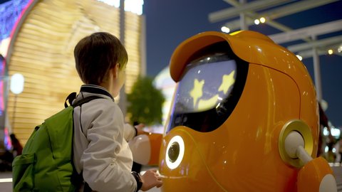 Dubai, United Arab Emirates - January 2022, Expo 2020 UAE. Happy boy child greets robot friend. Museum of future, machine intelligence artificial science robotics digital virtual communication concept