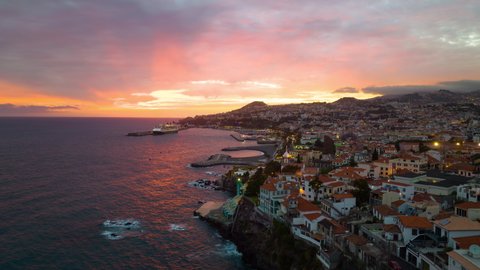 Drone timelapse video of the Funchal town at night. Night city on Madeira island. Madeira, Portugal at night. City lights of the Funchal night illuminated town on Madeira.