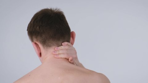 Man with neck pain over isolated background, back view