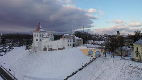 Grodno, Belarus-January 2022: a beautiful white old castle high on the castle hill above the river at sunset in late autumn. Aerial photography