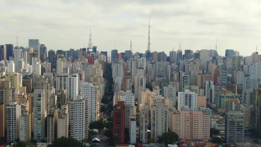 Sao Paulo Skyline during cloudy day with sun between clouds drone footage over Sao Paulo capital