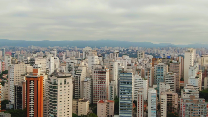 Sao Paulo Skyline during cloudy day with sun between clouds drone footage over Sao Paulo capital