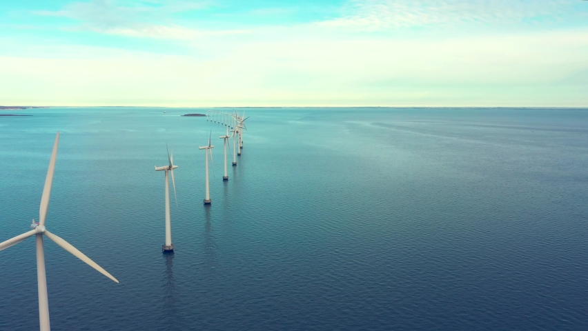 Oceanic windmill farm just outside Copenhagen. These wind turbines are a symbol of a sustainable energy source in a progressive, smart city. | Shutterstock HD Video #1086349865