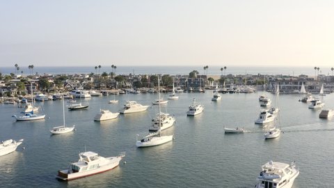 Aerial Moving Forward Over A Marina Full Of Boats To A Beachside House - Newport Beach, California