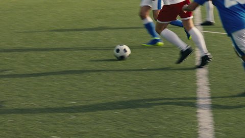 Close up of a soccer player receiving a pass and shooting the ball towards the goal on a soccer field. Soccer players are wearing unbranded sports clothes. 4k slow motion video.