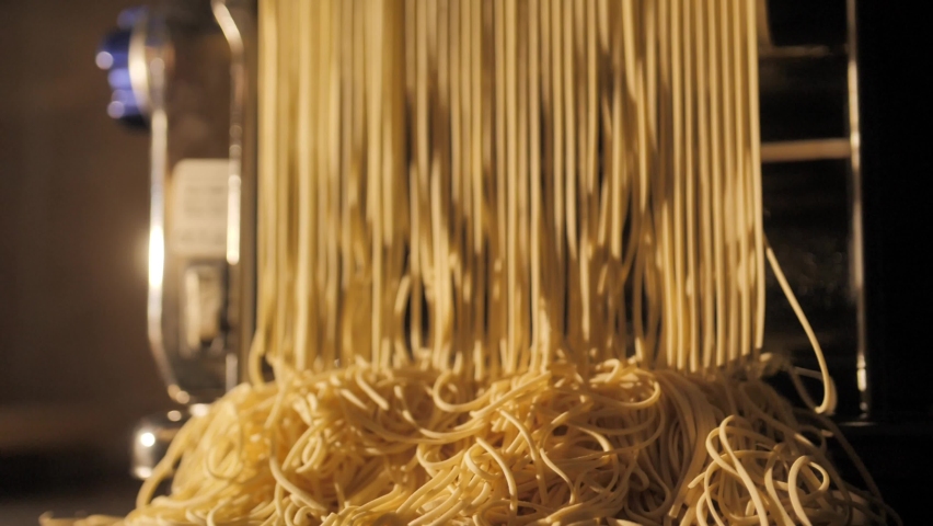 Production of pasta on a modern production line. Macaroni factory and pasta production. Raw spaghetti hung in a pasta factory, swinging, to dry Royalty-Free Stock Footage #1086354581
