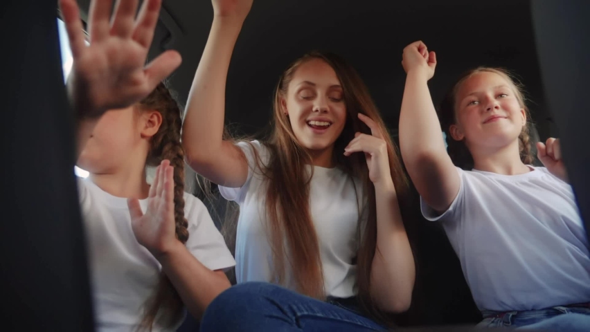 Children teenagers dancing in the car on the road travel. happy family adventure a kid dream concept. friendly family sisters dancing having fun to the music in the car on the way fun to vacation | Shutterstock HD Video #1086355190