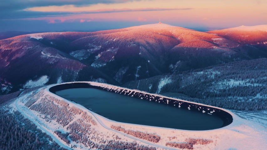 Pumped storage hydro plant "Dlouhe strane" in Jeseniky mountains during sunset. Aerial view on evening winter mountains. Third biggest pumped storage hydro plant in the world Royalty-Free Stock Footage #1086362558