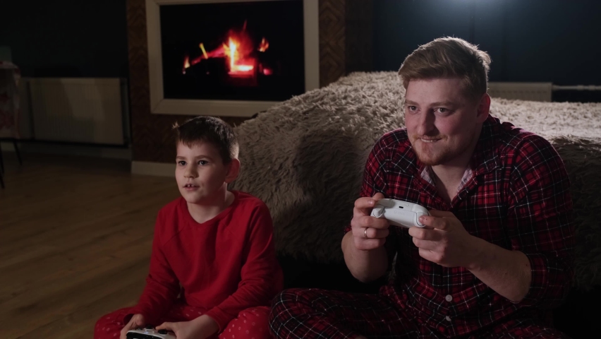 Father and little son playing video game