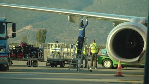 Bodrum, Turkey - October 10, 2021: Airport staff do ground operations of landed aircraft and aviation ground handling in airport Bodrum.