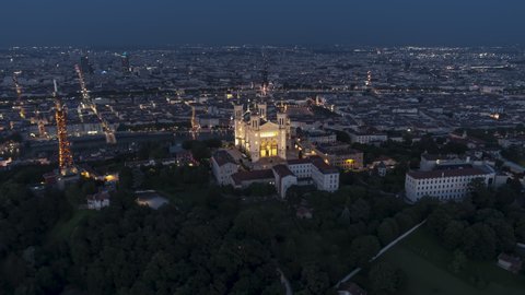 Push in, Basilica of Notre-Dame de Fourviere, Establishing Aerial View Shot of Lyon Fr, Auvergne-Rhone-Alpes, France at night evening