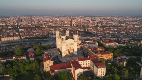Wide, sunset, circle to the right, Basilica of Notre-Dame de Fourviere, Establishing Aerial View Shot of Lyon Fr, Auvergne-Rhone-Alpes, France