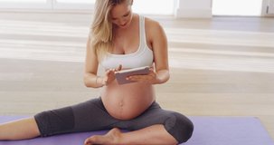 Check for safe prenatal videos online. 4K video of a pregnant woman looking at prenatal yoga videos online.