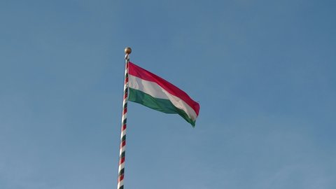 Hungarian flag or flag of Hungary waving against blue sky