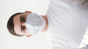 A young man removes on medical mask. Portrait man.