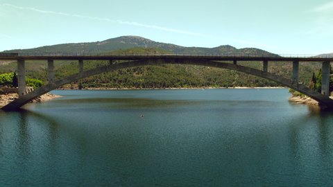 Aerial drone point of view arch bridge across El Burguillo Reservoir, located along Alberche river in province of Avila. Spain