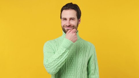 Secret fascinating young brunet bearded man 20s wears mint shirt look aside say hush be quiet do shhh gesture close his mouth lock and throw away key isolated plain yellow background studio portrait