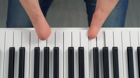 Man with amputated two stump hands is opening piano to play on it, closeup hands. Life of guy person musician with physical disability. He's trying to keep playing after the injury.