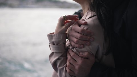 man hugging a girl in a raincoat close-up