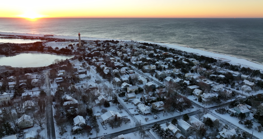 Cape May Point, New Jersey. Lighthouse and Atlantic Ocean at sunrise. Residential housing community in fresh snow in winter.