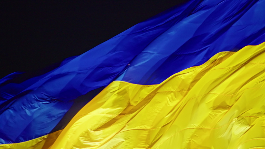 the flag of Ukraine, a silk flag flies against the background of the night sky on a large flagpole. Royalty-Free Stock Footage #1086413810